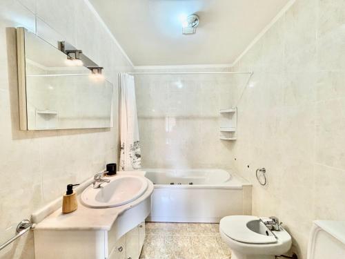 a bathroom with a sink and a toilet and a tub at NCHouse in Esposende
