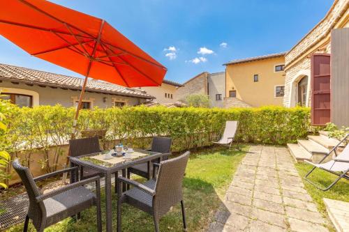 a patio with a table and chairs and an umbrella at Il Conventaccio Luxury Resort in Ficulle