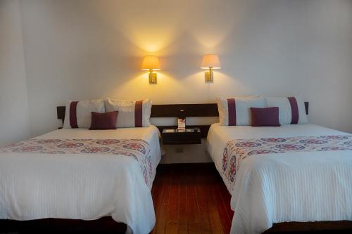 a hotel room with two beds and two lamps at Hotel Misión San Miguel de Allende in San Miguel de Allende