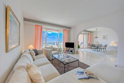 a living room with a couch and a table at Casa Monti Belvedere with Pool + Terrace Dining - Happy Rentals in Locarno