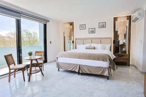 a bedroom with a large bed and a table and chairs at Hotel Guiant in Santa María del Río