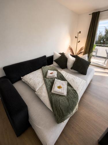a couch with pillows on it in a living room at Design Apartment 6 am Titisee mit Kamin, E-Ladestation, Balkon, Top Lage in Titisee