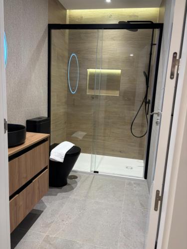 a bathroom with a shower with a toilet and a sink at La Encina Suites in Salamanca