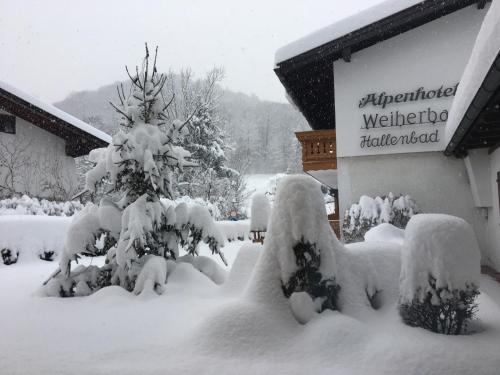 a yard covered in snow next to a sign at Ferienwohnungen Weiherbach - Hallenbad in Berchtesgaden