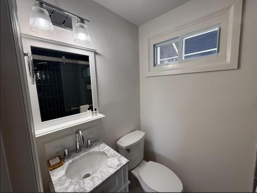 a bathroom with a toilet and a sink and a window at Oceana By The Sea in Point Pleasant Beach