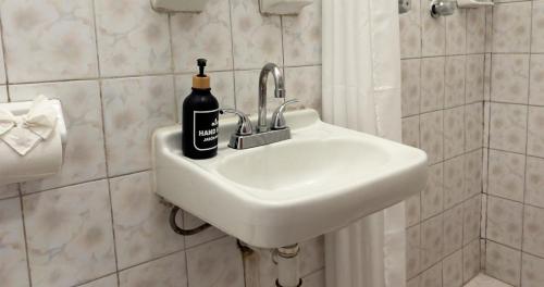 a bathroom sink with a bottle of soap on it at Hotel Posada Casa de la Tía in Oaxaca City
