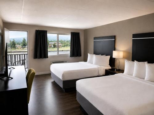a hotel room with two beds and a balcony at Expedition Lodge Estes Park at Rocky Mtn National Park in Estes Park