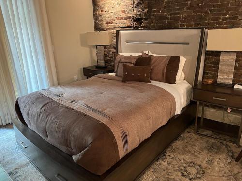 a bedroom with a large bed and a brick wall at Downtown Suite with Balcony in Syracuse