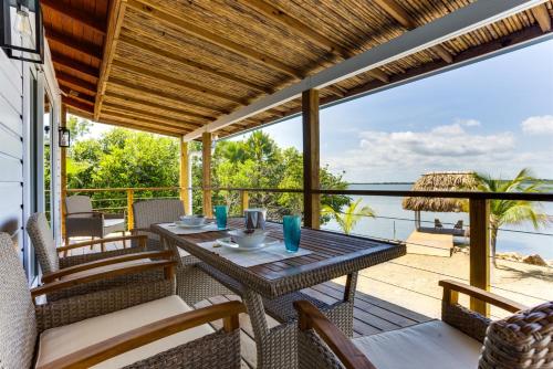 a dining table on a deck with a view of the ocean at Luxurious Lagoon Home w Elegant Decor & Pool in Maya Beach