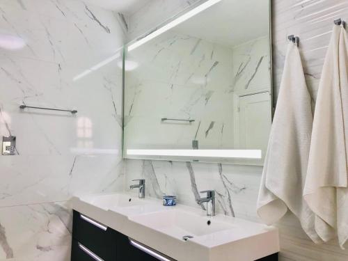 a white bathroom with a sink and a mirror at Luxury Casa da Fonte - Private Heated Salt Pool in Faro