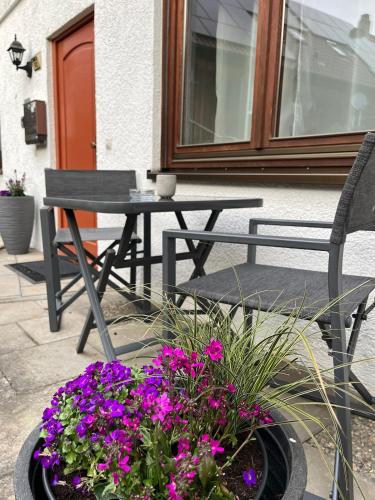 a patio with a table and a bench and flowers at Ferienwohnung Zum Rottweiler Städtle - Erdgeschosswohnung in Rottweil