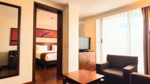 a hotel room with a bedroom with a bed and a mirror at Hotel American Blessing in Bogotá
