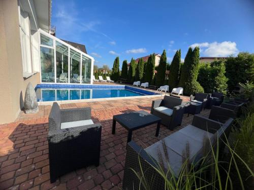 a patio with chairs and a swimming pool at Villa Melody in Rewal