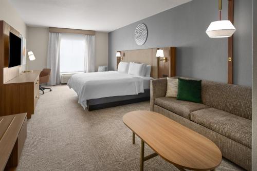 a hotel room with a bed and a couch at Holiday Inn Midland by IHG in Midland