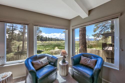 two blue chairs in a room with large windows at Tahoe Retreat on the Meadow- Hot Tub AC in South Lake Tahoe