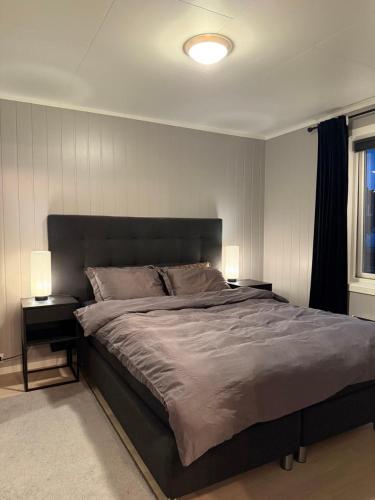 a bedroom with a large bed with two night stands at Lux Apartment Gravdal in Gravdal