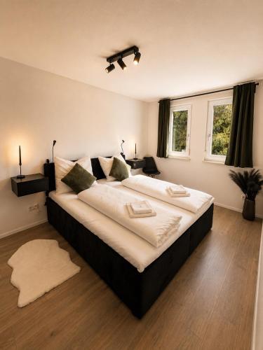 a large bedroom with a large bed with white sheets at Design Apartment 5 am Titisee mit Kamin, E-Ladestation, Balkon, Top Lage in Titisee-Neustadt