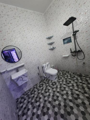 a bathroom with a toilet and a tv in it at RÉSIDENCE MAME DIARRA kl in Kaolack
