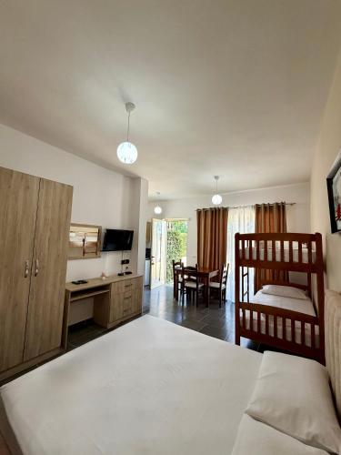 a bedroom with a bed and a desk and a television at "Seaside Pines" Apartments in Vlorë