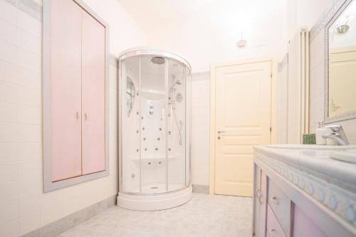 a white bathroom with a shower and a sink at Villa Lepre in Casarza Ligure