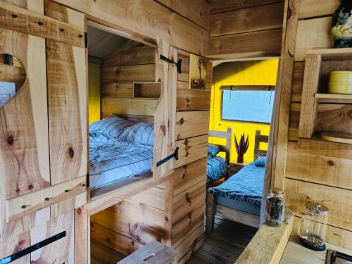 a wooden cabin with two bunk beds in it at Puy Rond Camping in Bressuire