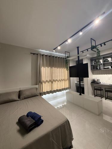 a bedroom with a large bed and a kitchen at Studio 44 Luxo Design Com Closet, Office e Ar in Mogi das Cruzes