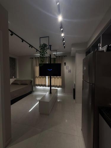 a living room with a couch and a tv in it at Studio 44 Luxo Design Com Closet, Office e Ar in Mogi das Cruzes