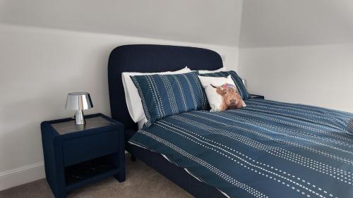 a dog sitting on top of a blue bed at The Coach House in Alyth