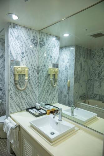 a bathroom with a sink and a mirror at Finest Guam Golf & Resort in Yigo