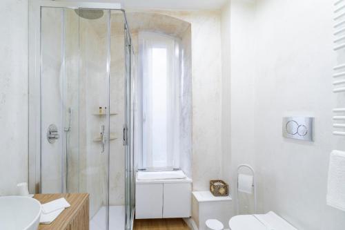 a white bathroom with a shower and a sink at Ponte Milvio Roma Elegance Room & Private Parking in Rome