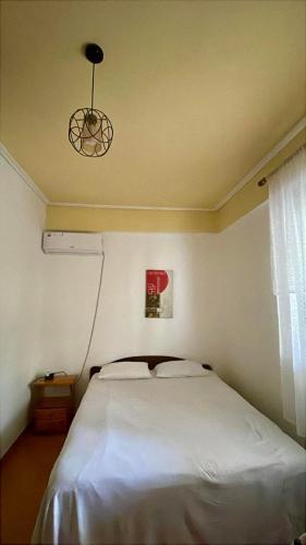 a bedroom with a white bed and a window at Mani rooms in Durrës