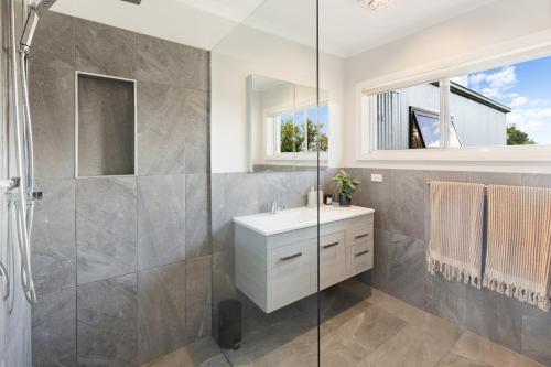 a bathroom with a shower and a sink and a mirror at Kidston Arches - HotTub - 2 Min Walk to Golf Course in Mansfield