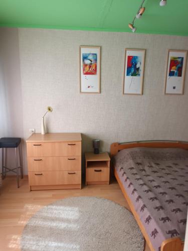 a bedroom with a bed and a dresser and pictures on the wall at 2 precu 17 in Daugavpils