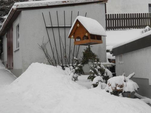 a bird house sitting on top of a pile of snow at Ferienhaus Zittau Oberlausitz & Ferienwohnung am Hamann Berg in Zittau