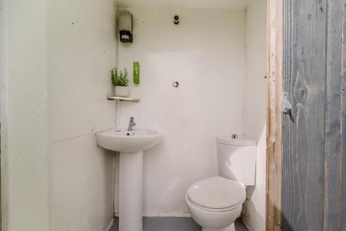 a white bathroom with a toilet and a sink at 1 Bed in Bude oc-s34881 in Bude
