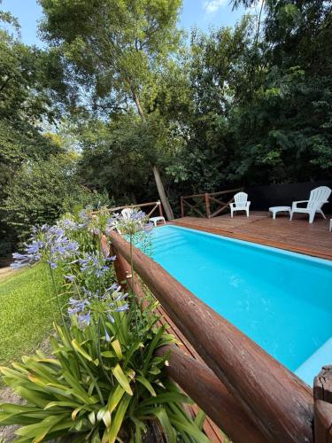 a swimming pool in a yard with flowers at Cabañas Grazie in Oliveros
