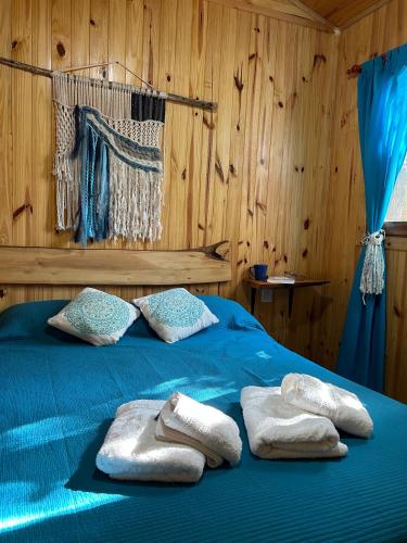 two towels on a bed in a wooden room at Cabañas Grazie in Oliveros