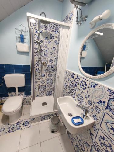 a blue and white bathroom with a toilet and a sink at fairytale home - panorama in Agropoli