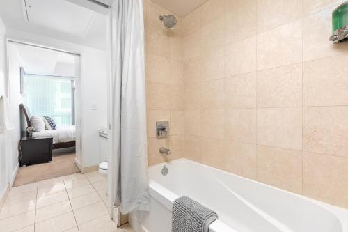 a bathroom with a bath tub and a toilet at Downtown Toronto CN tower Condo in Toronto