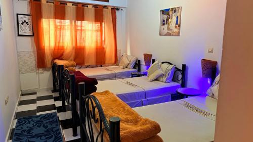 a room with three beds and a window at Dar Rita in Rabat