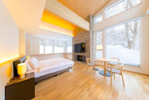 a bedroom with a bed and a desk and a table at Rose - Rusutsu Chalets in Kimobetsu