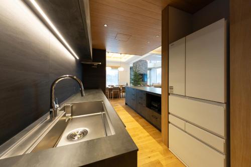 a kitchen with a stainless steel sink and a counter at Rose - Rusutsu Chalets in Kimobetsu
