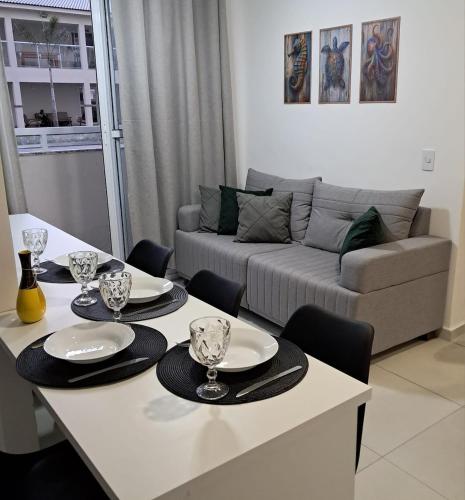 a living room with a table and a couch at Apto com ar e piscina próximo a Cabo Frio e Arraial do Cabo in São Pedro da Aldeia
