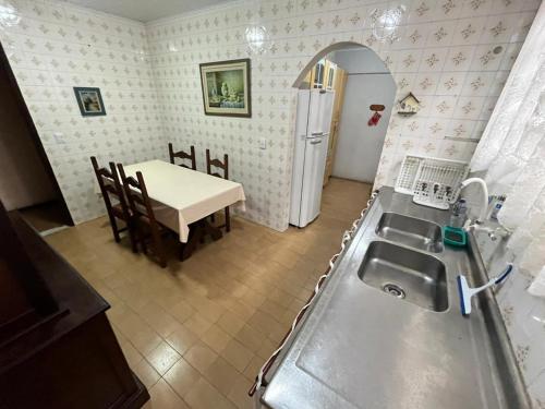 a kitchen with a sink and a table with a dining room at Casa aconchegante para família- 3,5 km do centro histórico in Petrópolis