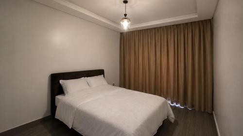 a bedroom with a white bed and a window at Parc app in Mohammedia