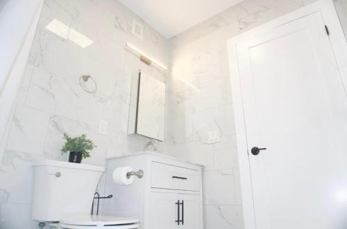 a white bathroom with a toilet and a sink at New York view 37 in West New York
