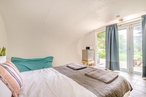 a white bedroom with a bed and a large window at 1 Bed in Bude oc-s34858 in Bude