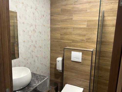 a small bathroom with a toilet and a sink at DION Hotel & Restaurant in Kumanovo