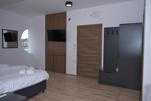 a bedroom with a bed and a flat screen tv at DION Hotel & Restaurant in Kumanovo