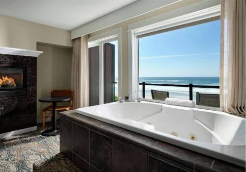 a large bath tub in a room with a fireplace at Starfish Manor Oceanfront Hotel in Lincoln City